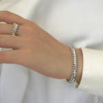 Жорсткий браслет Cartier Clash з рухливими елементами срібло, на руці