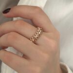 Каблучка Cartier Clash з рухливими елементами та логотипом рожеве золото на руці