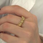 Каблучка Cartier Clash з рухливими елементами та логотипом лимонне золото на руці