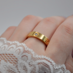 Каблучка Cartier з логотипом та камінням цирконію лимонне золото на руці
