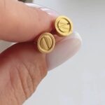 Сережки-пусети Cartier з логотипом золото на руці