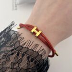 Нитковий браслет Hermes на затяжці золото/червоний на руці