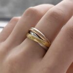 Широка потрійна каблучка Cartier з логотипом на руці