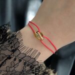 Нитковий браслет Cartier з логотипом червоний на руці