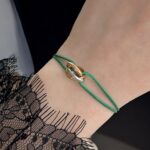 Нитковий браслет Cartier з логотипом зелений на руці