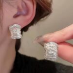 Сережки у вигляді розплавленого металу та маленьких хвиль срібло на вусі