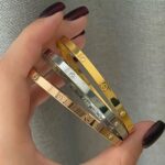 Тонкий жорсткий браслет Cartier з камінням та логотипом