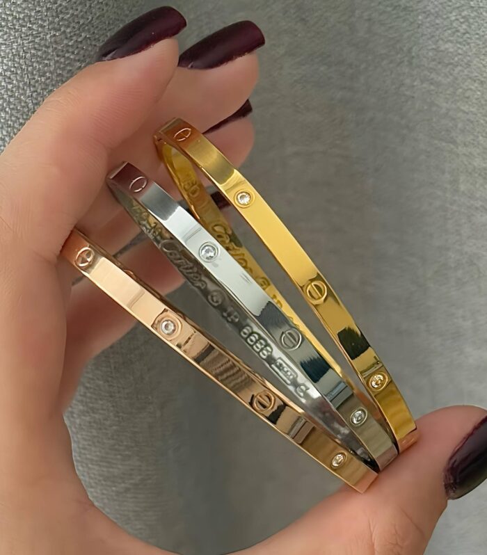 Тонкий жорсткий браслет Cartier з камінням та логотипом