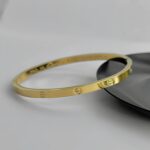Тонкий жорсткий браслет Cartier з логотипом лимонне золото