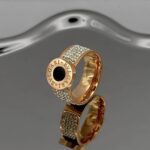 Широка каблучка BVLGARI з круглим логотипом та камінням золото чорний1