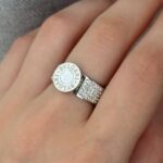 Широка каблучка BVLGARI з круглим логотипом та камінням срібло білий на руці