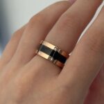 Каблучка BVLGARI з чорною серцевиною та логотипом рожеве золото на руці