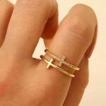 Подвійна каблучка з камінням з колекції Tiffany T золото на руці
