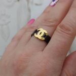 Чорна каблучка Chanel з логотипом лимонне на руці