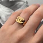 Широка каблучка Chanel з логотипами золото на руці