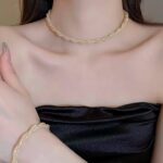 Сплетений підвіс та браслет з камінням всередині: комплект прикрас золото на тілі