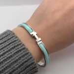 Вишуканий жорсткий браслет Hermes з логотипом у сріблі зелений на руці