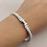 Вишуканий жорсткий браслет Hermes з логотипом у сріблі білий на руці