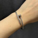 Тонкий жорсткий браслет-цвях Cartier у камінні срібло на руці