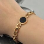 Ланцюговий браслет BVLGARI з чорним логотипом на руці