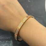 Жорсткий браслет Cartier у камінні з логотипом рожеве золото на руці