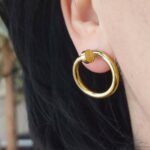 Круглі сережки Cartier у вигляді вигнутого цвяха золото на вусі