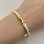 Вишуканий жорсткий браслет Hermes з логотипом у лимонному золоті білий