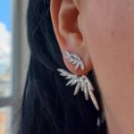 Сережки-джекети з камінням у вигляді пір'я на вусі