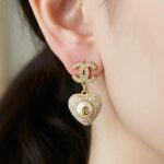 Ніжні сережки Chanel з перламутровими підвісками-сердечками та камінням на вусі