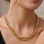 Ланцюговий підвіс Dior з логотипом лимонне золото на тілі